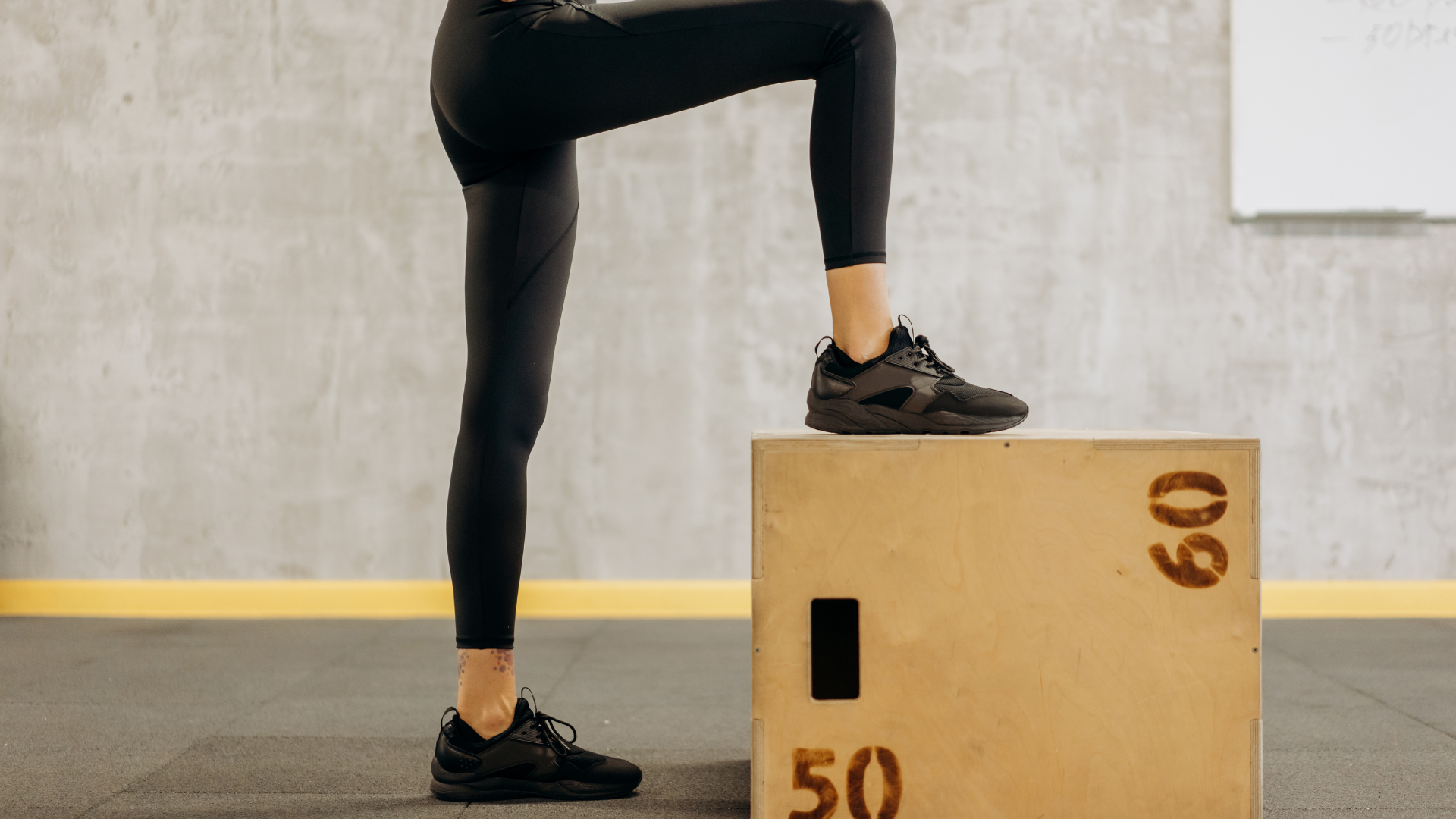 person stepping on to CrossFit box