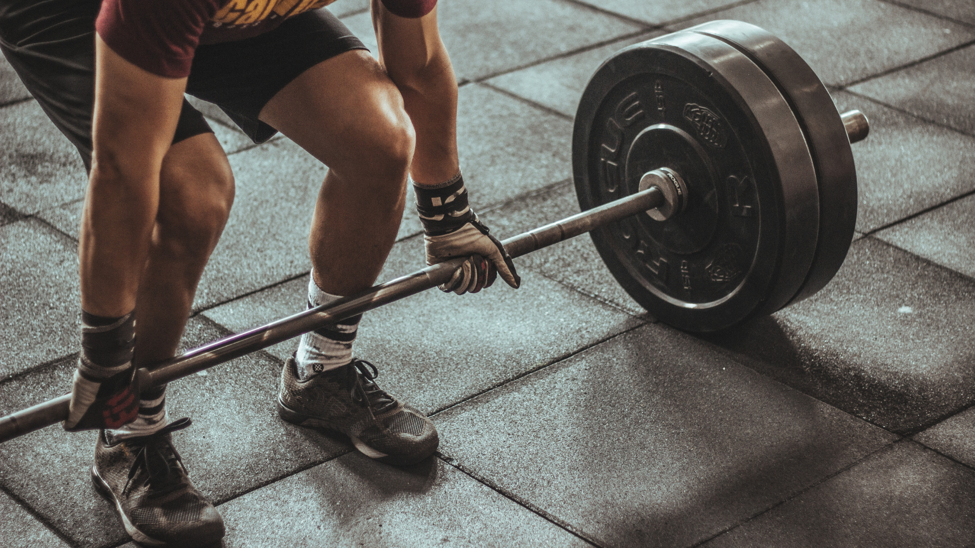 athlete reaching for barbell